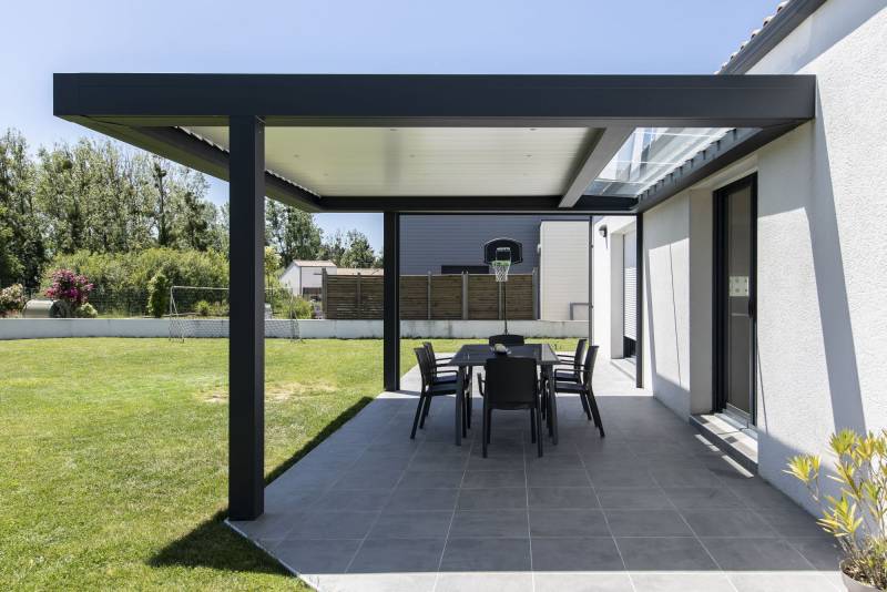 Pergola Bioclimatique à lames orientables et un débord de toit vitré pour une entrée de lumière maximale. 